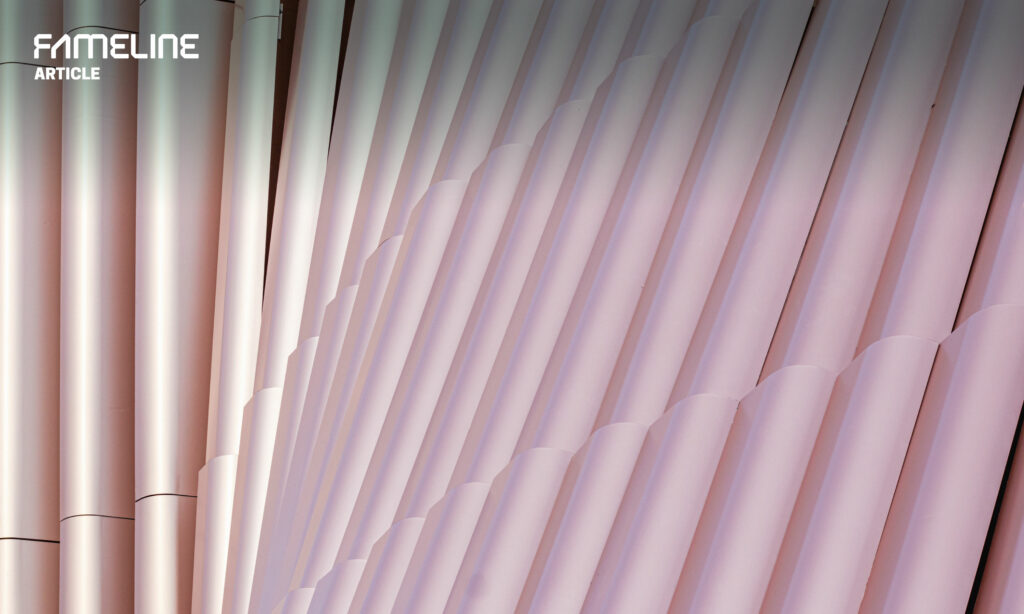 Close-up view of a pink-tinted aluminum honeycomb panel facade from FAMELINE, highlighting innovative construction materials, energy-efficient design, and architectural aesthetics for sustainable urban development and design flexibility in modern architecture articles.
